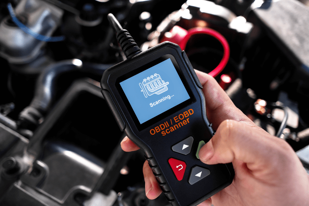 smog test, auto repair in Racine, WI at Durand Automotive. Hand holding an OBD-II scanner diagnosing a vehicle engine for error codes.