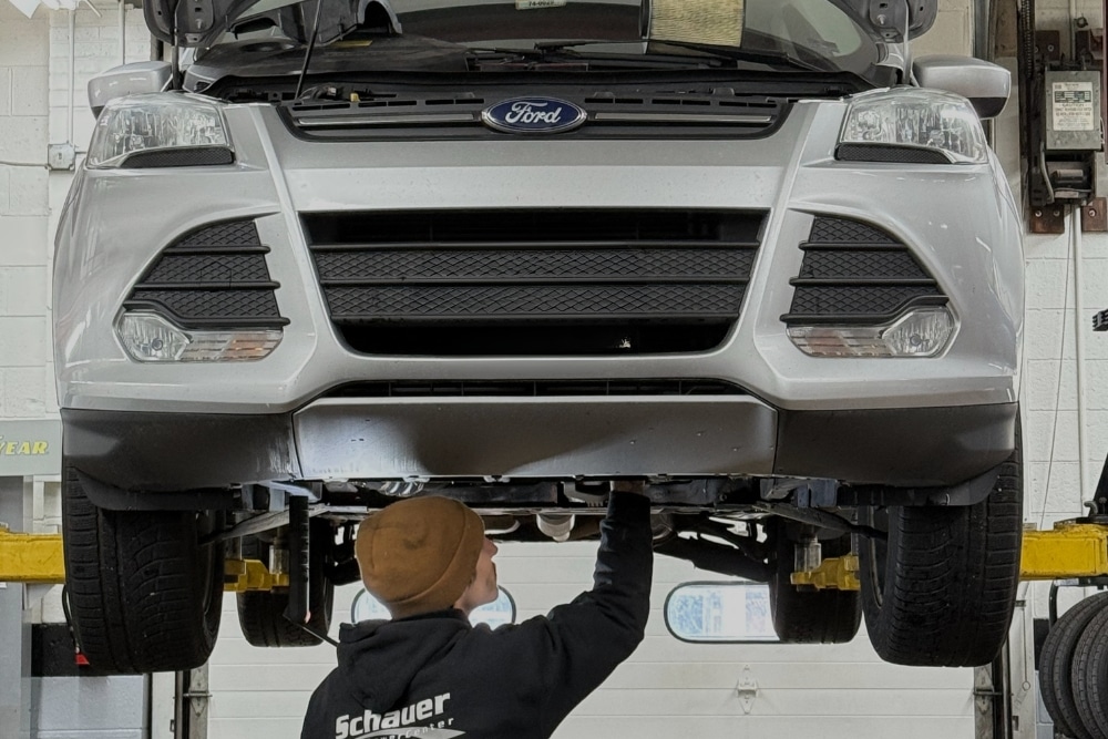 Back-to-School Car Maintenance in Racine, WI At Durand Automotive. Mechanic inspecting a car on a lift at an auto repair shop for maintenance