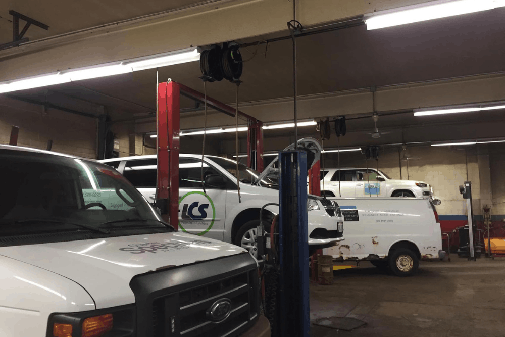 Fleet services in Racine, WI at Durand Automotive. Image of commercial fleet vans and service vehicles inside an auto repair shop, highlighting professional fleet repair and preventative maintenance solutions.