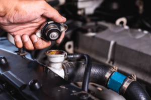 Cooling System Inspection in Racine, WI At Durand Automotive. A mechanic inspects a radiator cap for damage during a cooling system inspection to prevent engine overheating.