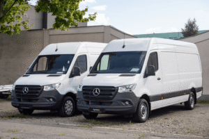 Preventative maintenance for fleets, auto repair in Racine, WI at Durand Automotive. Image of two white Mercedes-Benz Sprinter cargo vans parked side by side, highlighting commercial van maintenance and reliability.