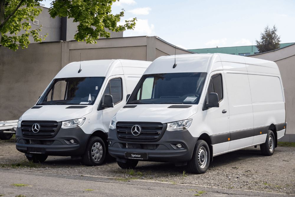 Preventative maintenance for fleets, auto repair in Racine, WI at Durand Automotive. Image of two white Mercedes-Benz Sprinter cargo vans parked side by side, highlighting commercial van maintenance and reliability.